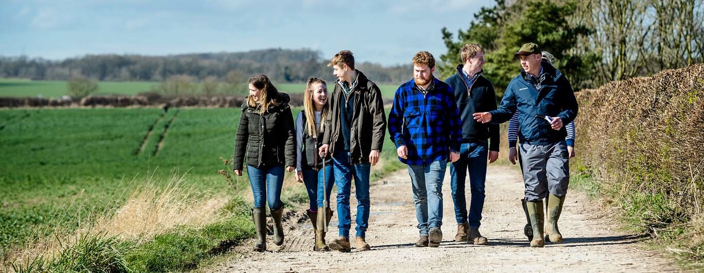 Agri banner Agriculture degree students walk past crop fields on the farm