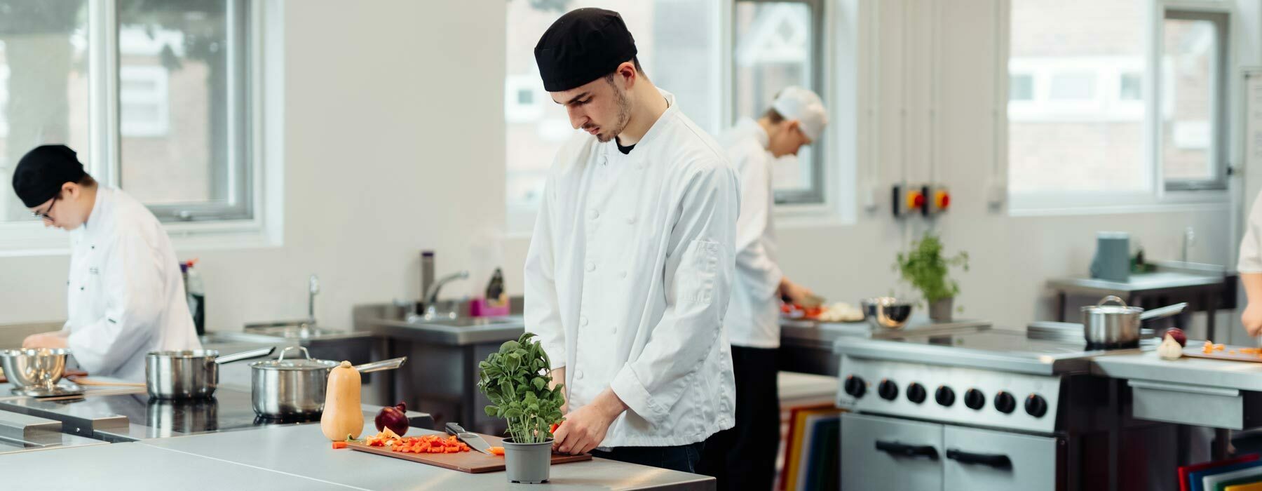 Food banner Professional Cookery students working in kitchens
