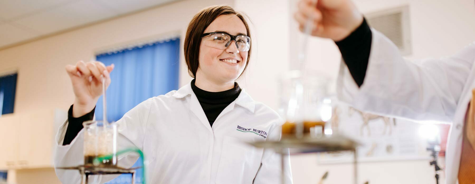 Forensic banner Applied Science student smiling whilst working in lab